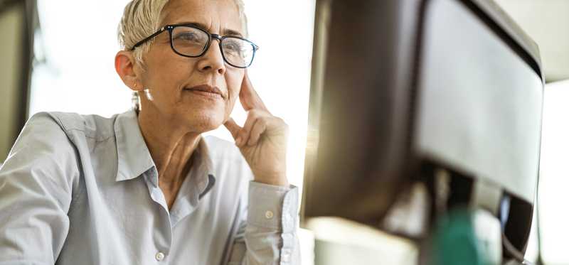 Person in glasses is using computer.
