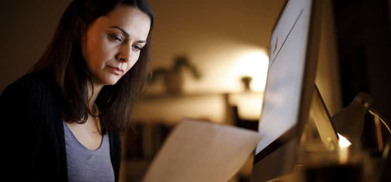 Person holding document and looking at it.