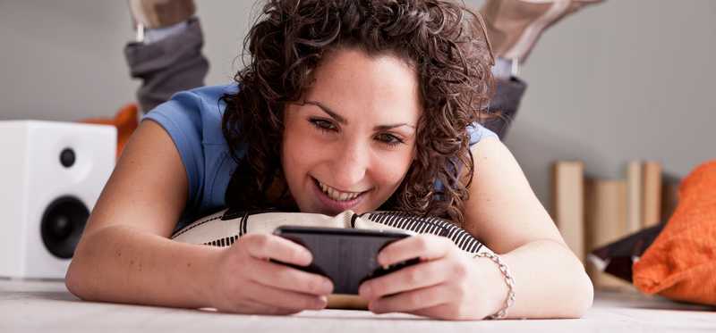 Person holding a cell phone as if playing a mobile game.