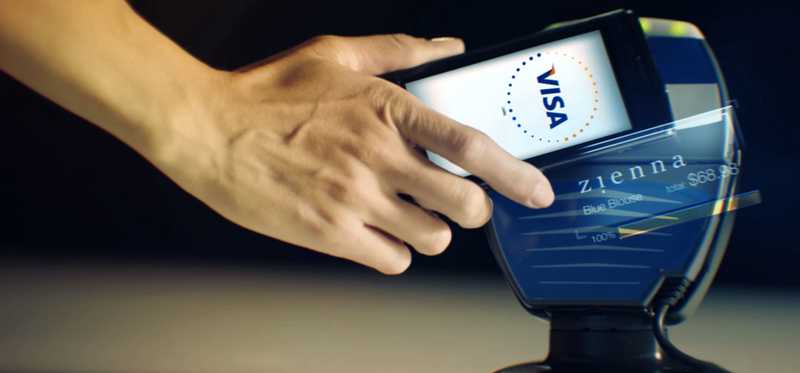 A person uses a cell phone for a mobile payment via Visa.