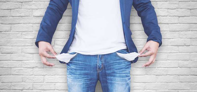 A person pulls out their jean pockets to reveal they're empty.