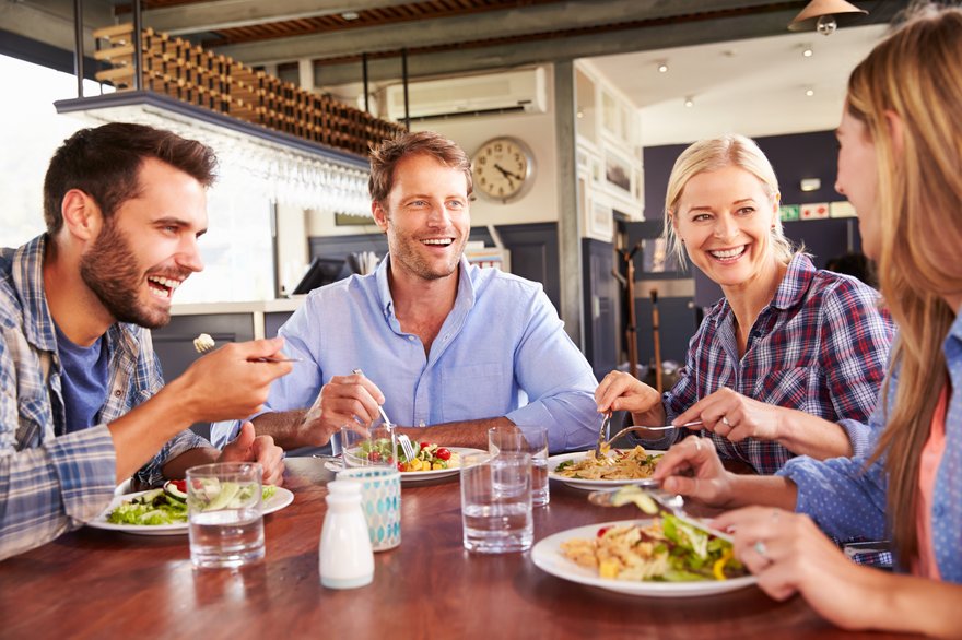 Four people eating lunch at a restaurant.