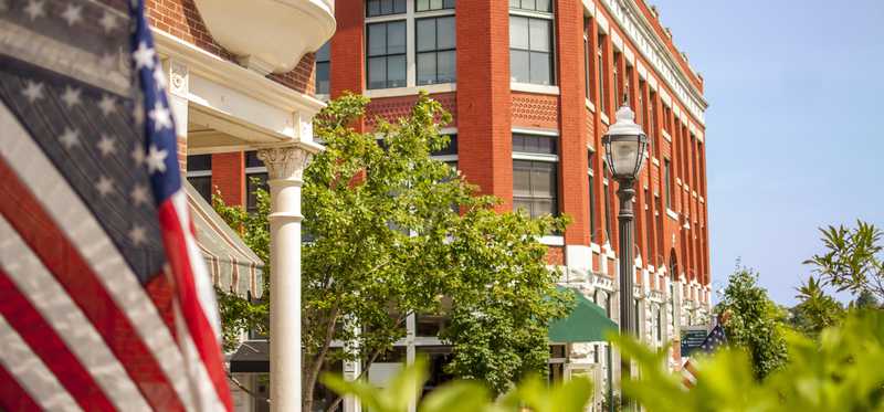 American flag and downtown red brick building.