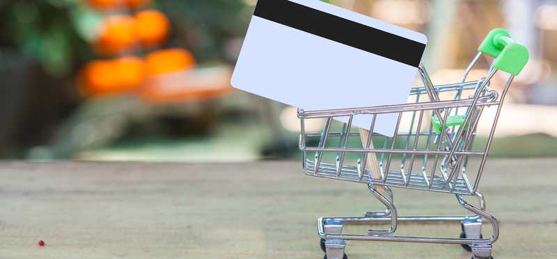 A shopping cart with a giant gift card in it.