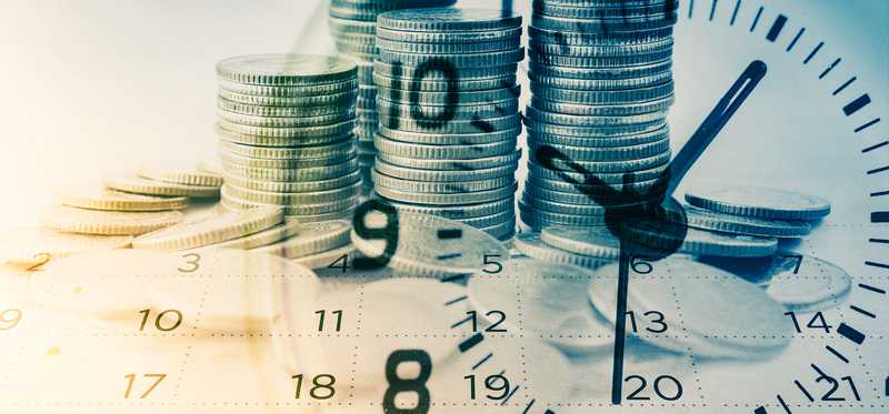 Stacks of coins with the image of a clock and calendar superimposed over them.