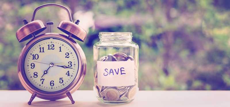 Alarm clock next to jar of coins labeled Save.