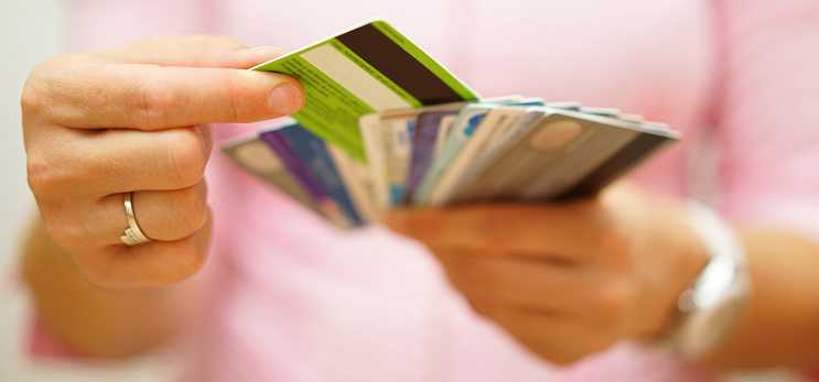 A woman sorts through a stack of credit cards.