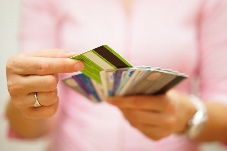 A woman sorts through a stack of credit cards.