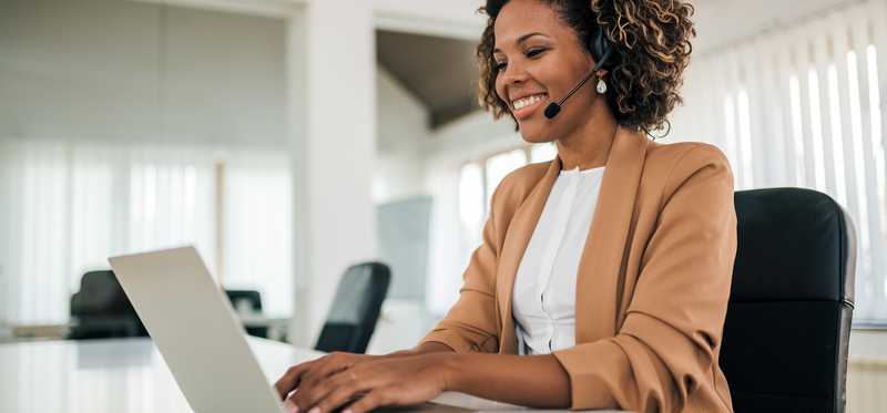 Woman working on laptop and smiling