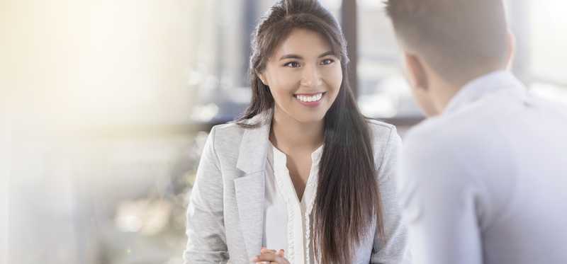 People meeting in an office with charts on table in front of them.