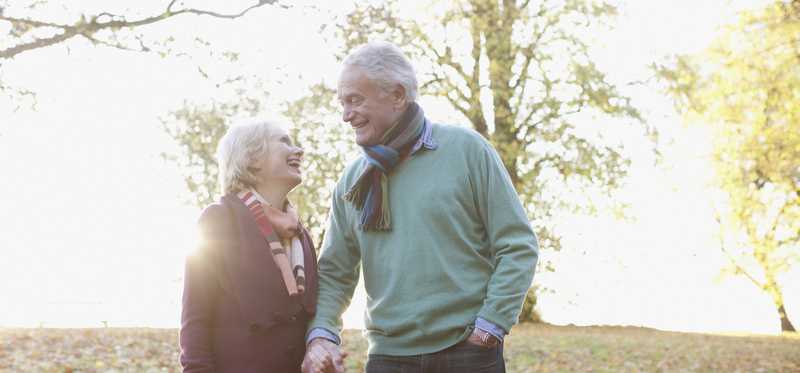 Senior couple holding hands outdoors.