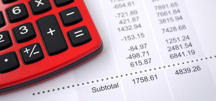 A red calculator sits on top of a financial statement.