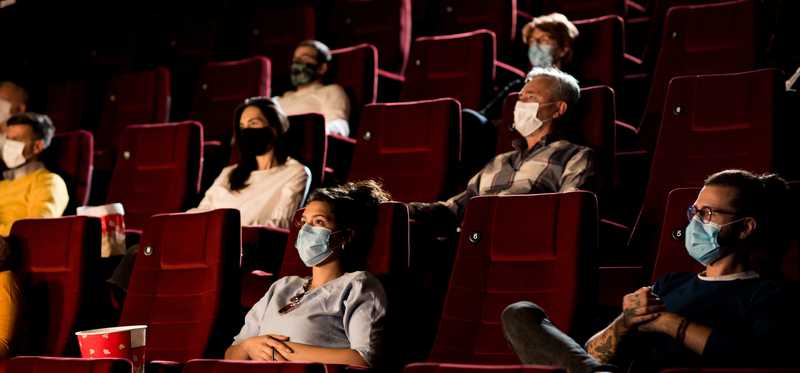 People wearing masks in movie theater.