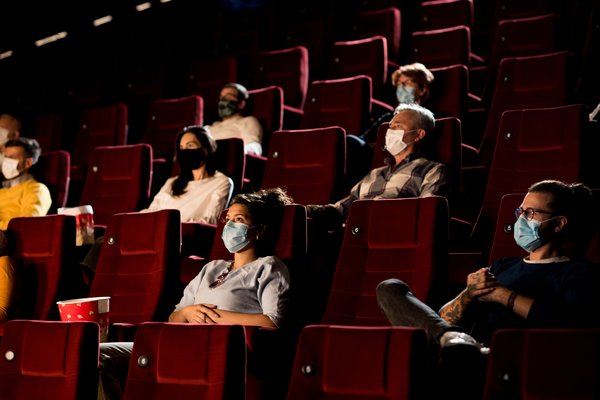 People wearing masks in movie theater.