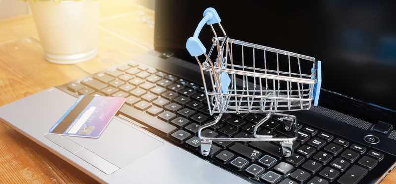 Shopping cart and credit card on laptop keyboard