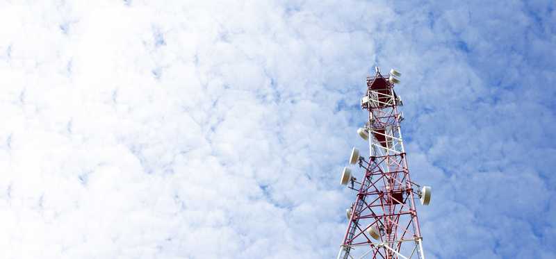 A large antenna against a partly cloudy sky