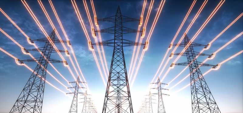A view looking up at multiple power lines overhead.