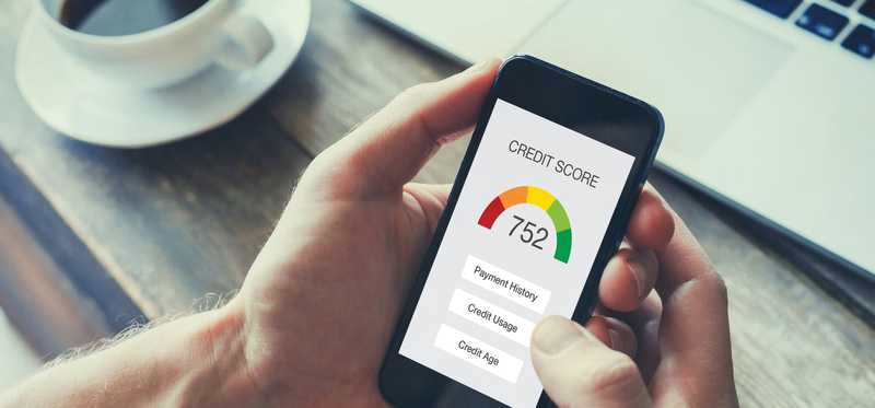 Hands holding cell phone showing credit score of 752.