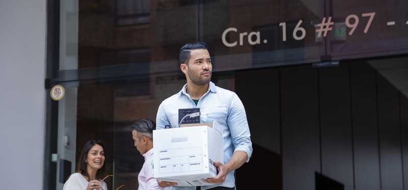 Man carrying cardboard box in front of office building