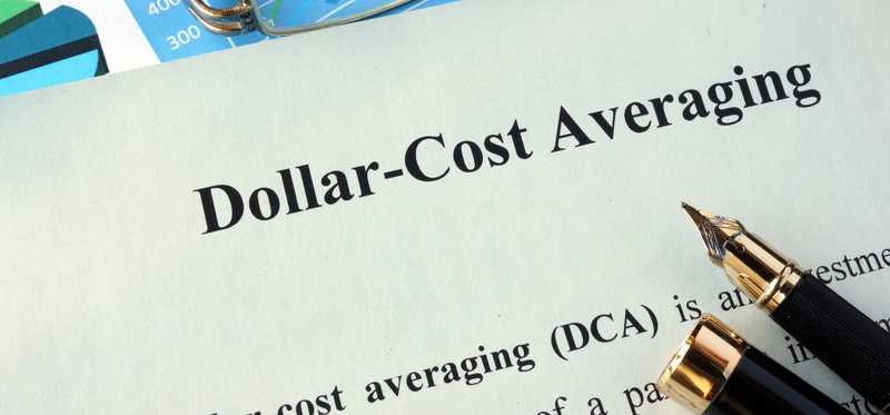 Paper saying Dollar-Cost Averaging next to pen and glasses.
