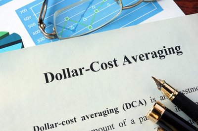 Paper saying Dollar-Cost Averaging next to pen and glasses.