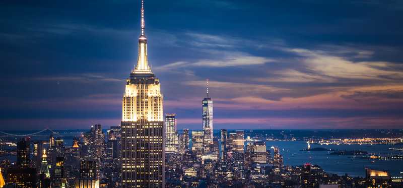 Empire State Building and downtown New York City seen at dusk.