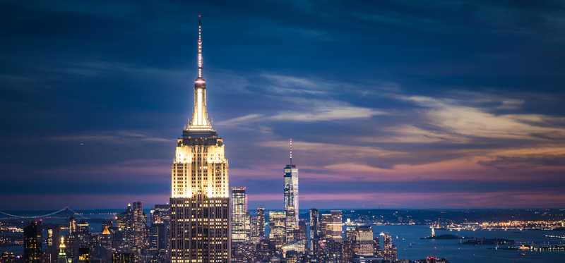Empire State Building and downtown New York City seen at dusk.