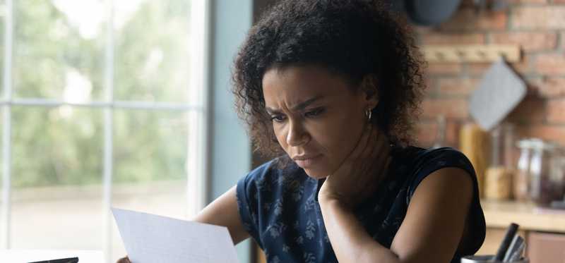 Adult frowns while looking at paperwork.