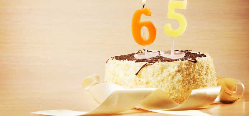 A birthday cake with candles numbered six and five.