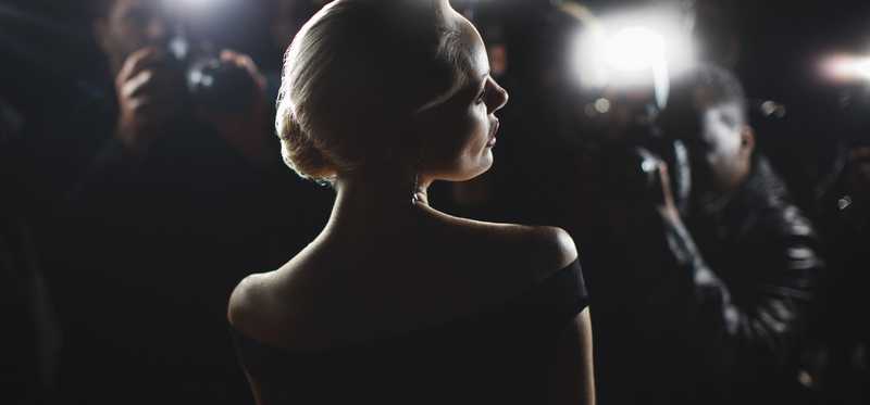 A supermodel backlit by flashing camera lights.