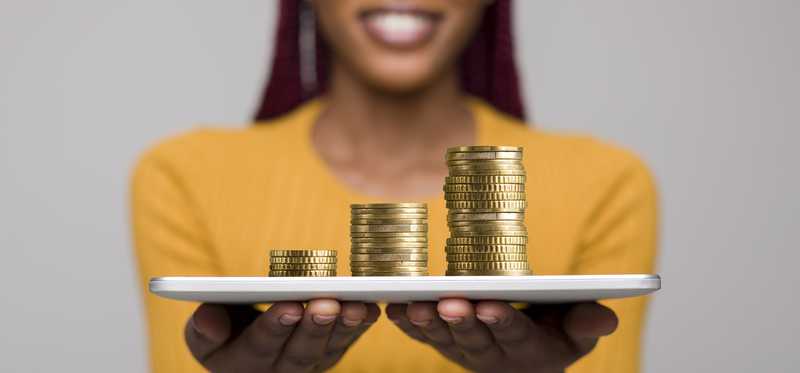 Woman holding tray with stacks of coins