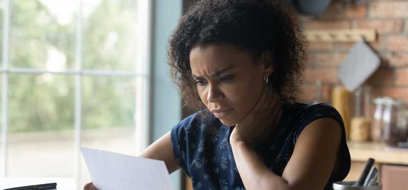 Worried person looking at piece of mail.