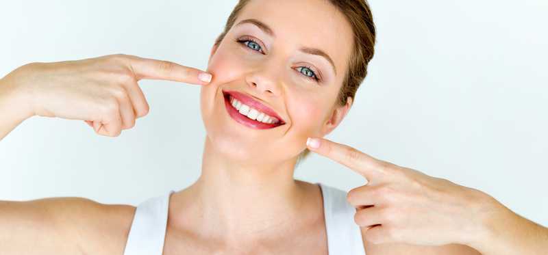Woman pointing to her big smile