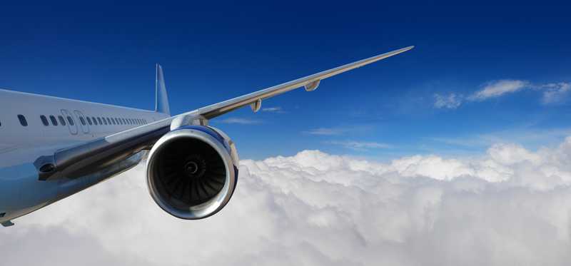 Jet engine on plane in clouds.