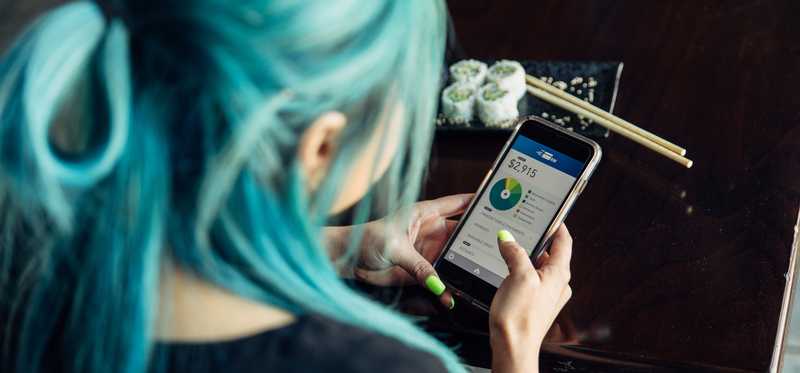 Person checking bank account through a financial app on their smartphone.