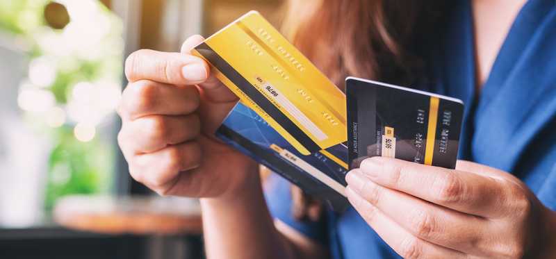 Woman chooses a credit card from a selection in her hand.