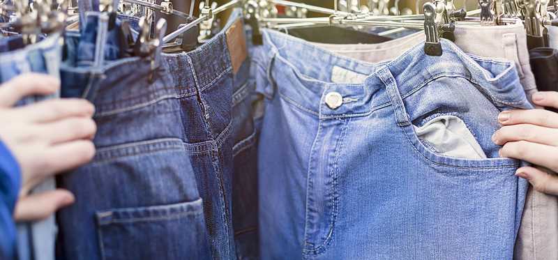A used clothing rack of jeans.