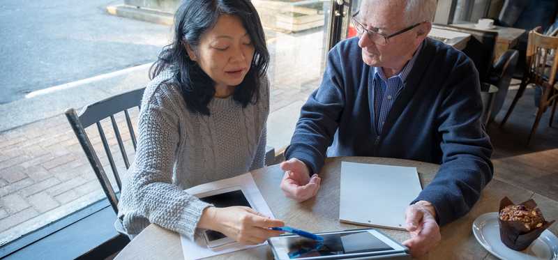 Two people review finances at table at home.