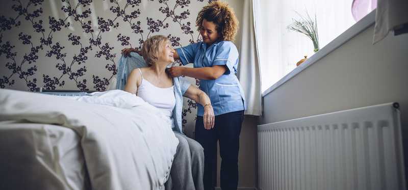 Healthcare working assisting a patient at home.