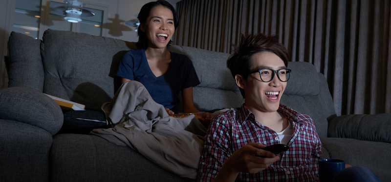 A couple watches tv at home.