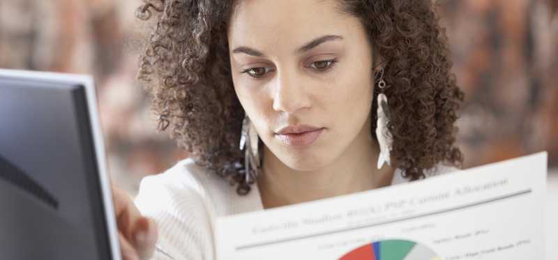 Person holding paperwork with pie chart.