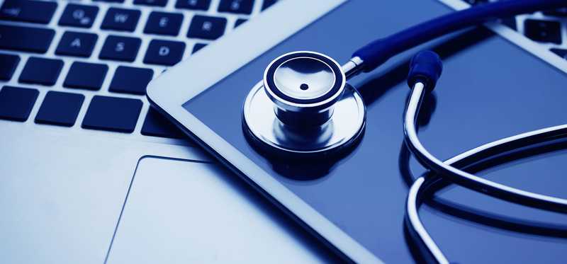 Stethoscope and smartphone on laptop keyboard