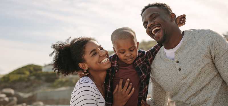 Two adults with a child at the beach.