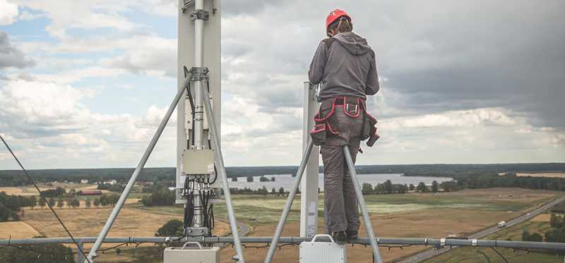 A person working on a cell tower far above the ground.