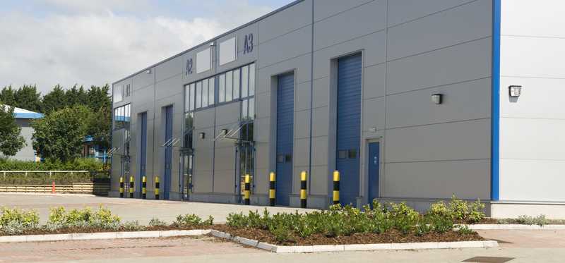Exterior of a small warehouse with bay doors.