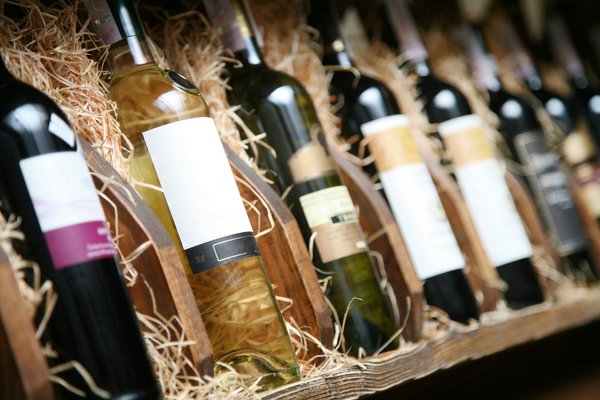 Assorted bottles of wine sitting in hay-filled crates.