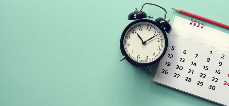 Alarm clock next to calendar