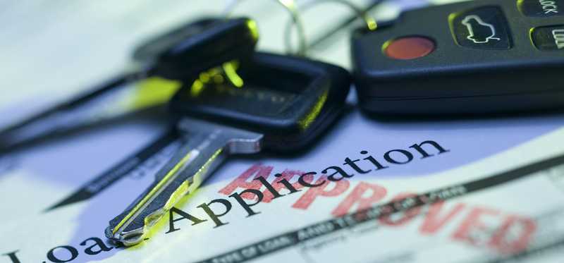 Car keys lying on top of auto loan application.