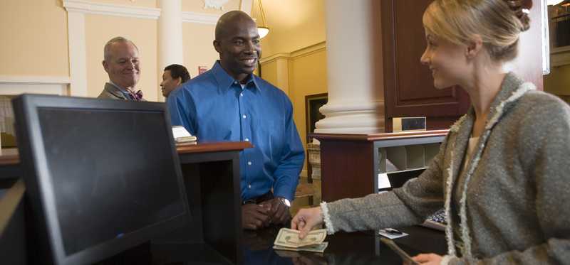 A bank teller handing cash to a customer.