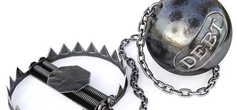 A bear trap with an attached weighted ball that has the word Debt engraved on it.